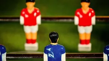 Close-up of foosball table with red and blue players.