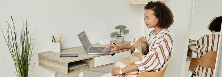 Vrouw werkt achter laptop, geniet van flexibel werken en verbetert work life balance door op afstand te werken vanuit haar thuiskantoor